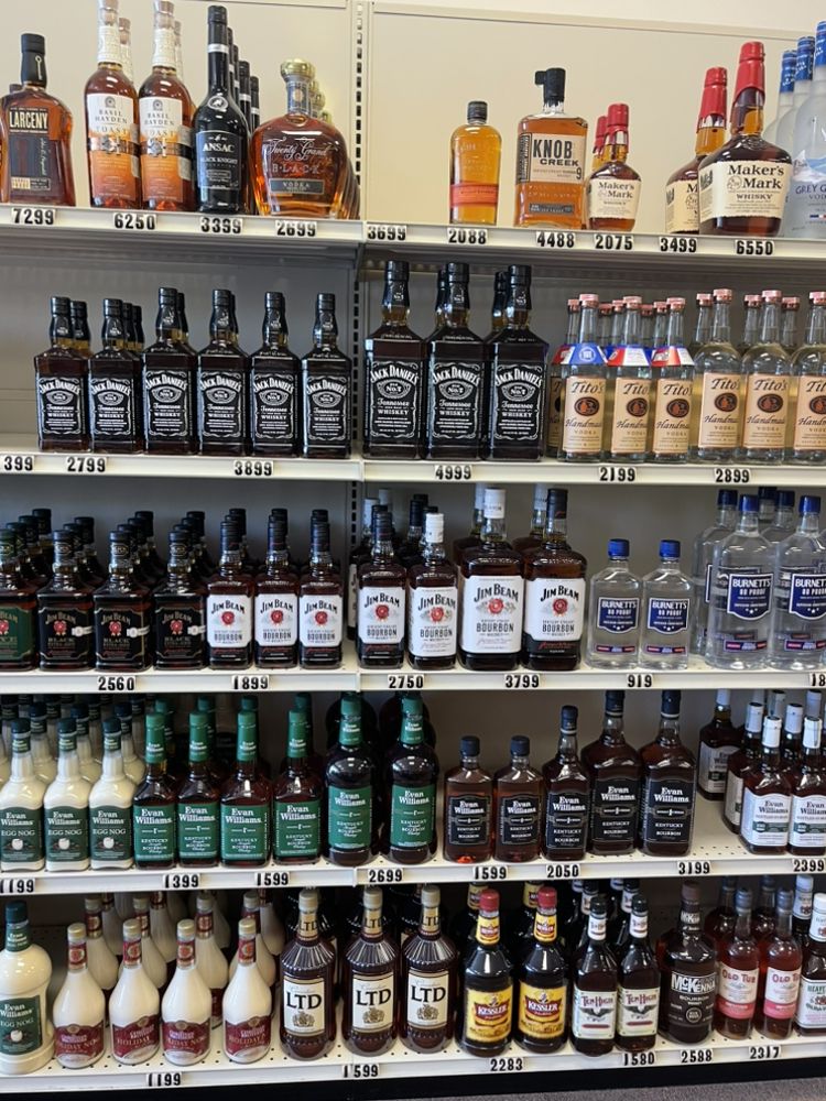 A shelf containing Jack Daniels, Jim Beam, Burnetts, Maker's Mark, Evan Williams