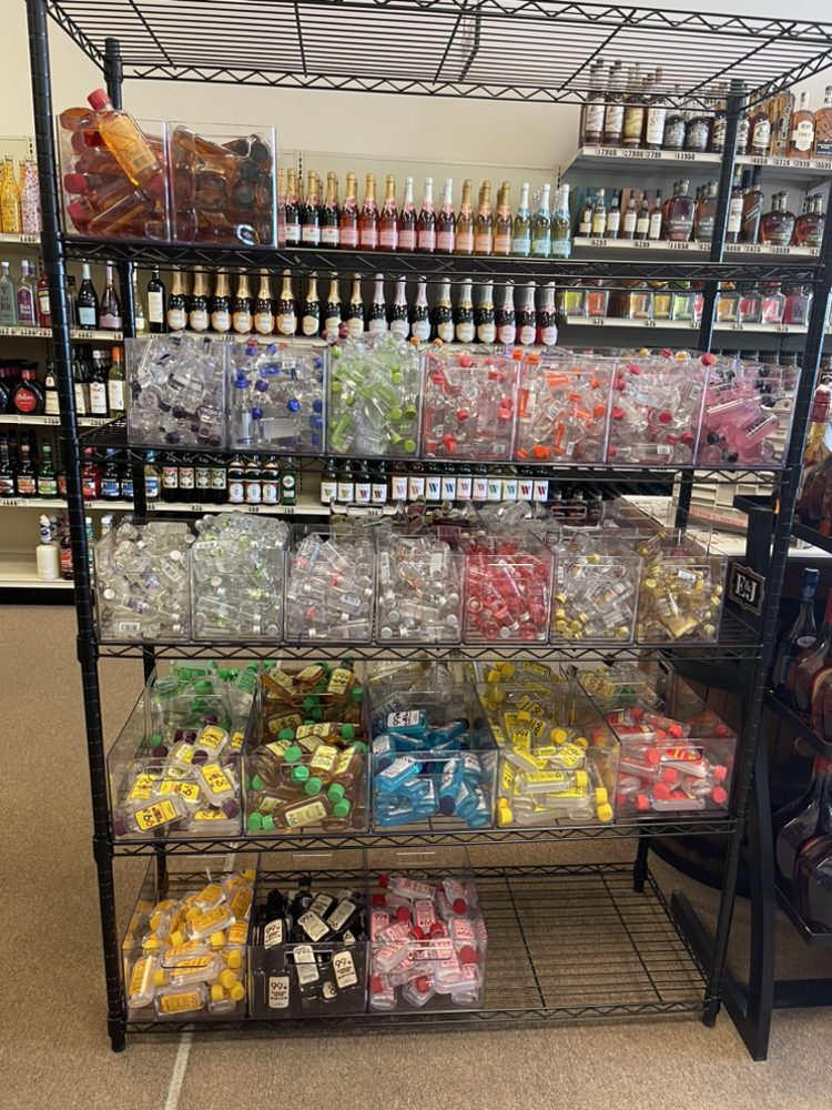 A rack full of small liquor bottles in our store separated neatly in clear bins